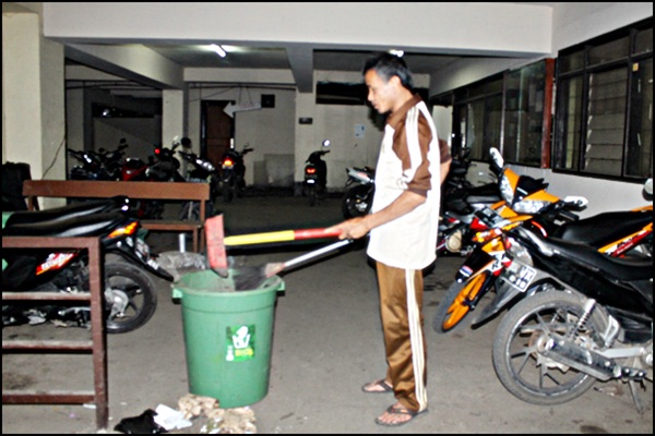 Maman membersihkan sampah yang berserakan di basement kampus Unpas Tamansari. Agung Gunawan Sutrisna/JUMPAONLINE