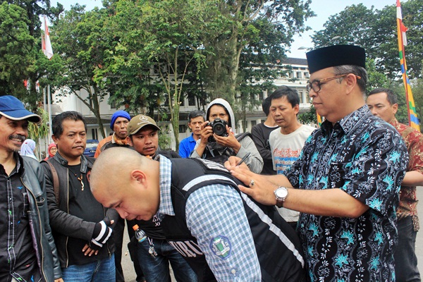 Elih Sudiapermana akhirnya memberikan tanggapan pada demonstran dengan membuat janji tertulis di atas kertas dan disaksikan oleh seluruh demonstran. (Sudury Septa Mardiah/JUMPAONLINE)
