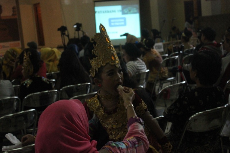 Seorang ibu sedang menyuapi anaknya yang merupakan salah satu peserta Pasanggiri Seni Sunda ke-14. (Dian Puspitasari Bintoro / JUMPAONLINE)