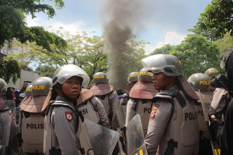 Puluhan Polisi yang diturunkan untuk berjaga-jaga saat aksi berlangsung, menghalangi massa berbaju hitam yang hendak bergabung dengan massa yang berasal dari Serikat Buruh. (M Taruna Prima Rahardi / JUMPAONLINE)